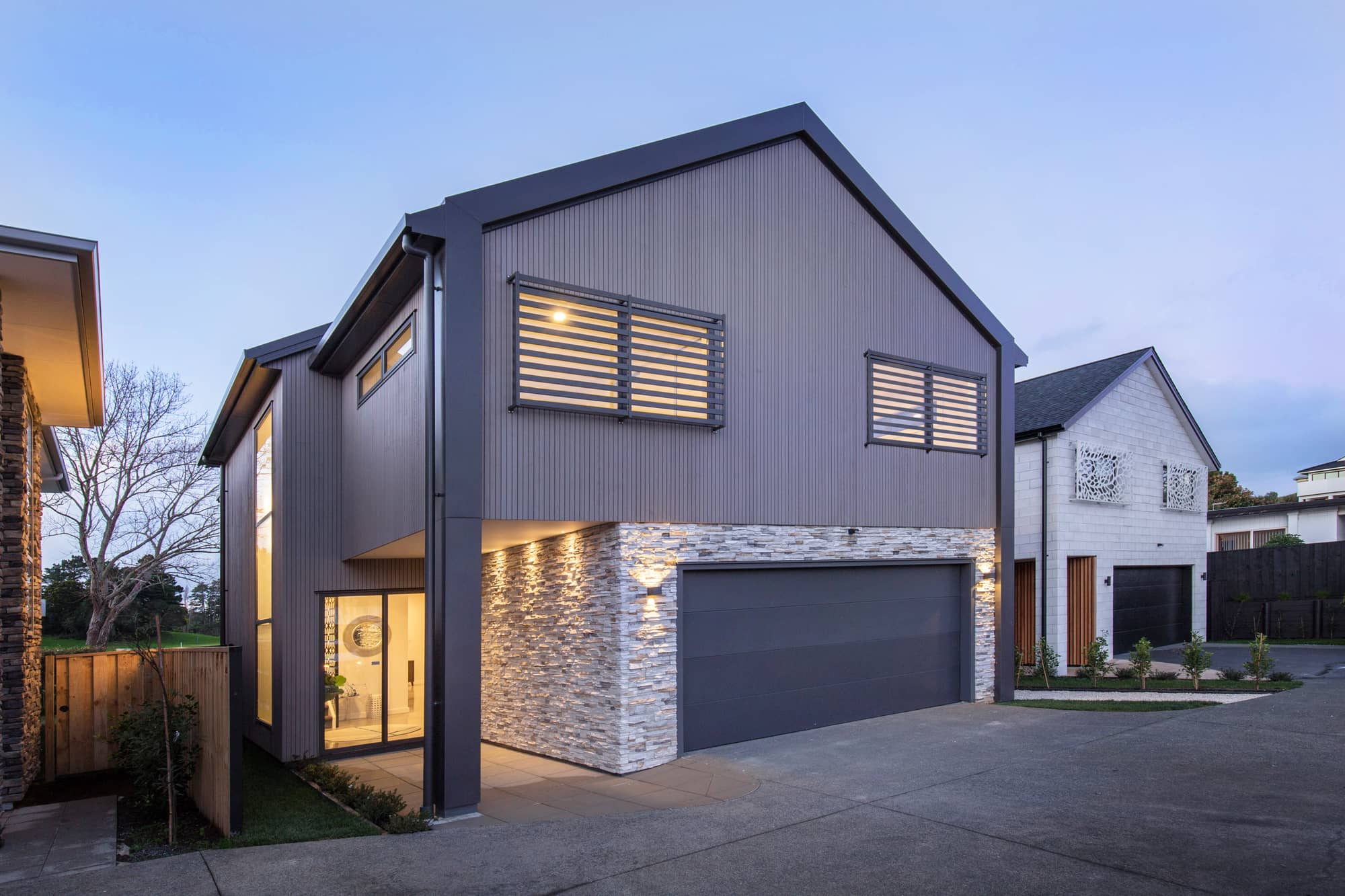 Modern two-storey home at dusk with LED exterior lighting.